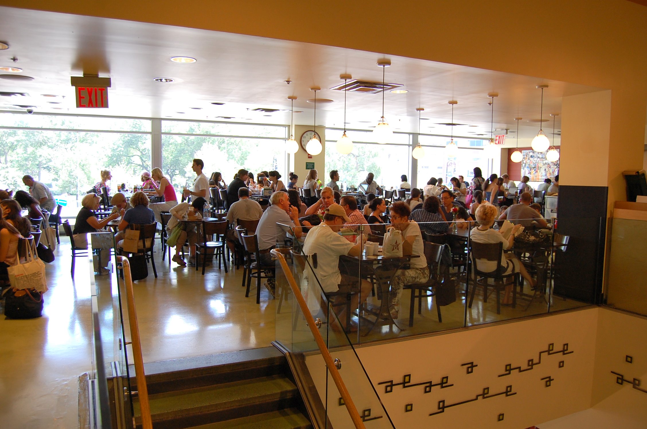 a cafeteria with tables and people sitting at the counter