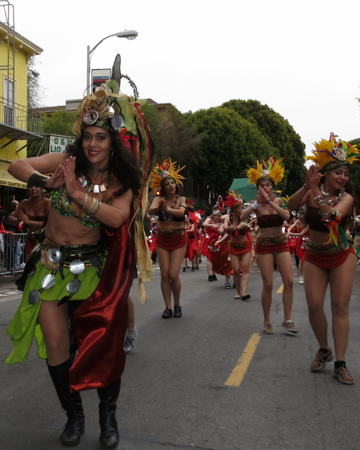 the women in costume are dancing along the street