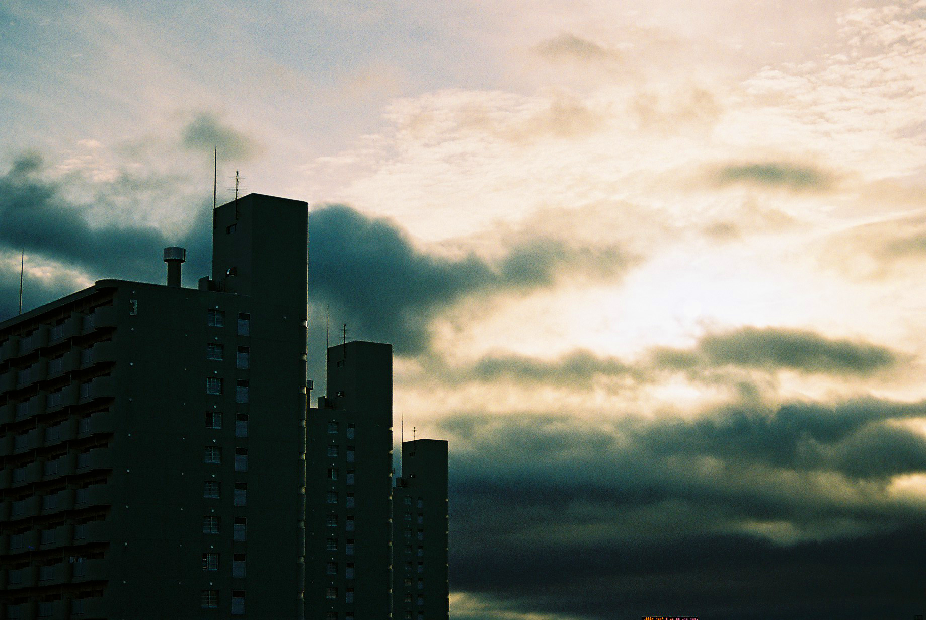 some very tall buildings in front of a cloudy sky
