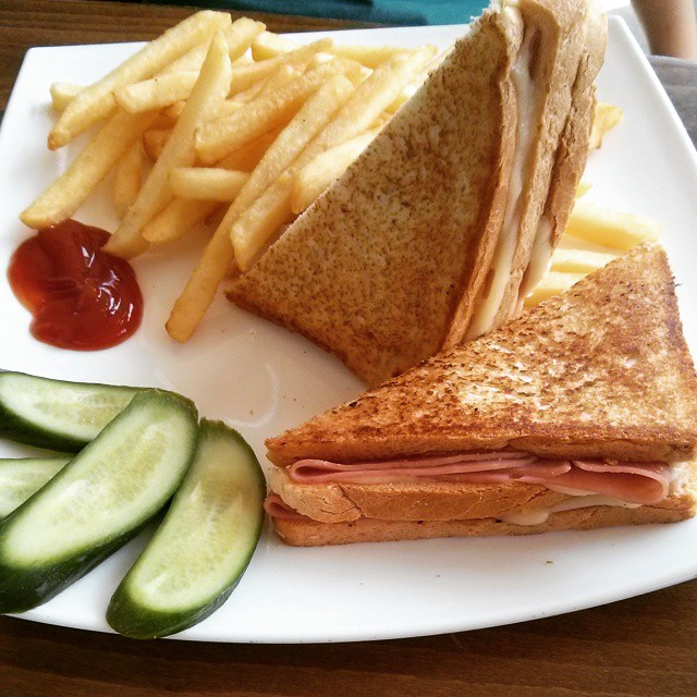 a sandwich with meat and fries and ketchup on a plate