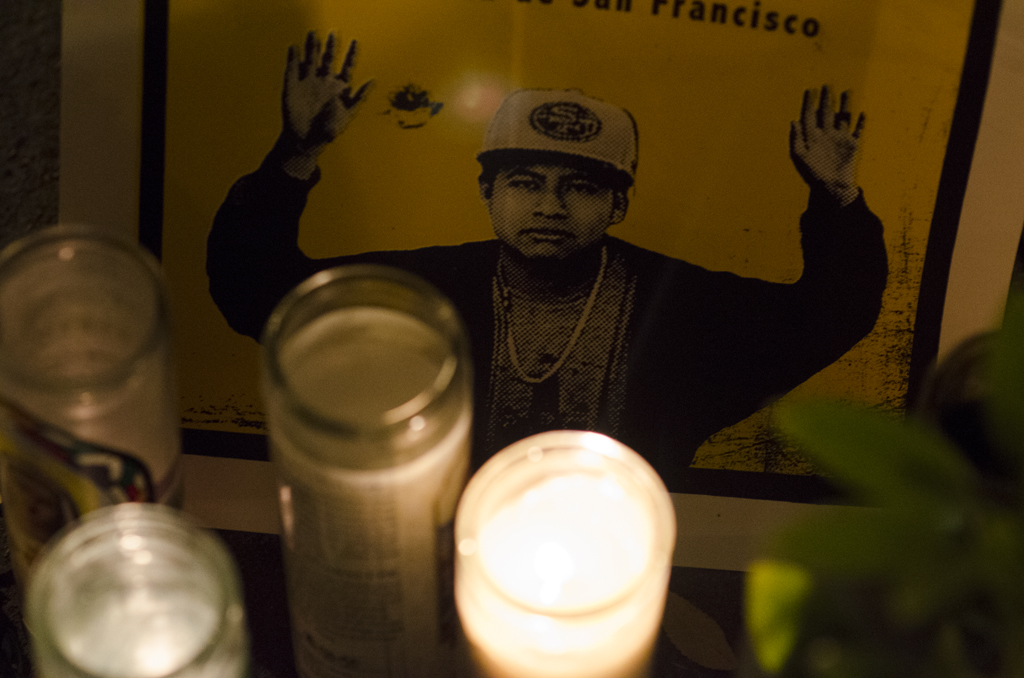 candles and wall pictures surround a man in a cap
