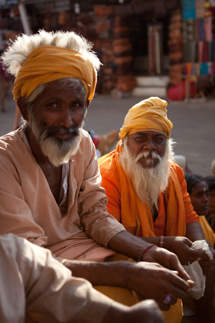 an old man with a turban and beard in front of others