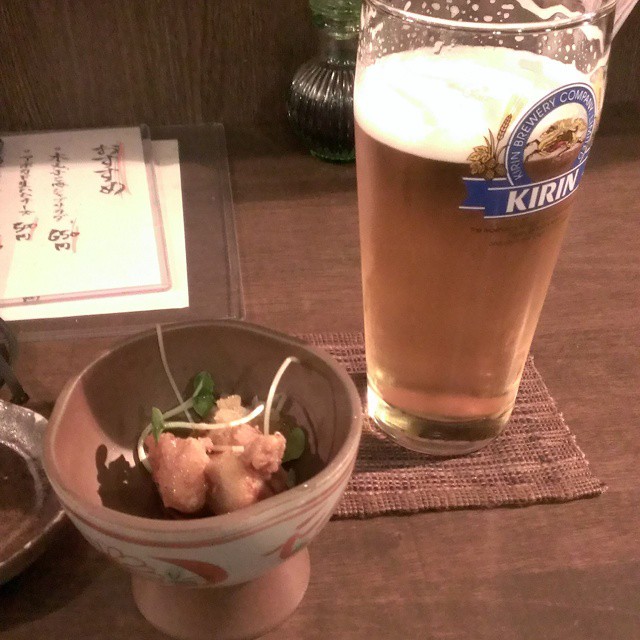 there is a glass of beer and a bowl of food