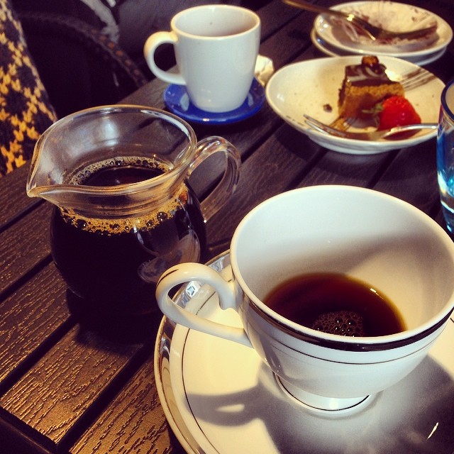 a meal with a coffee pot on the edge of a wooden table