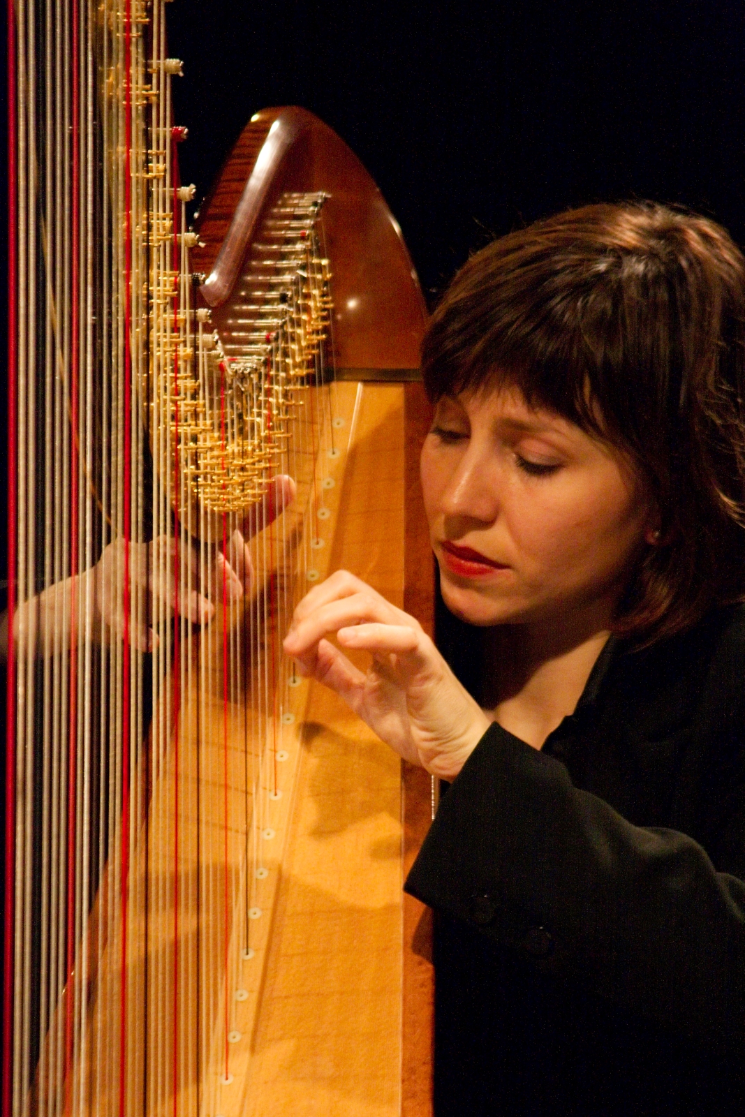 a woman is looking at a very large string instrument