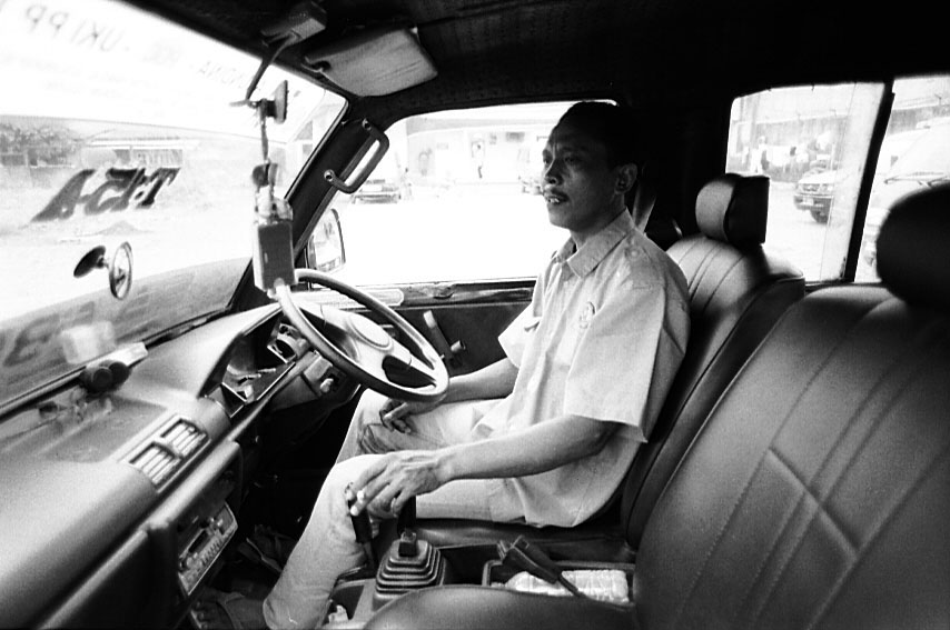 an old po of a man driving in the drivers seat