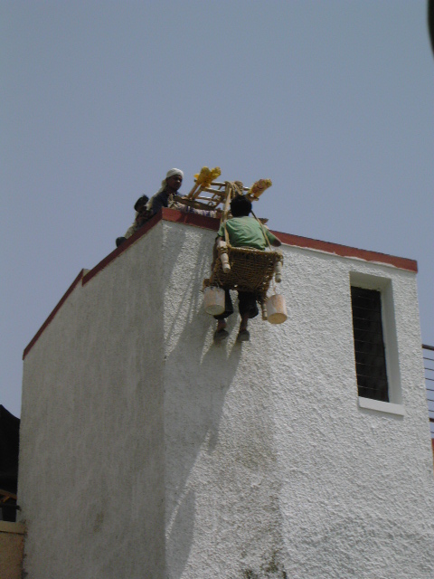 some people sitting on the side of a white house