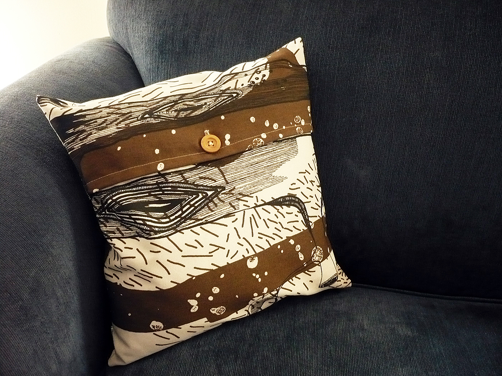 a decorative cushion sits on a black couch