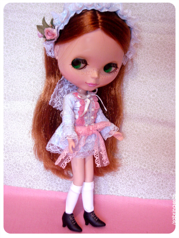 a doll is wearing an overdress and white lace