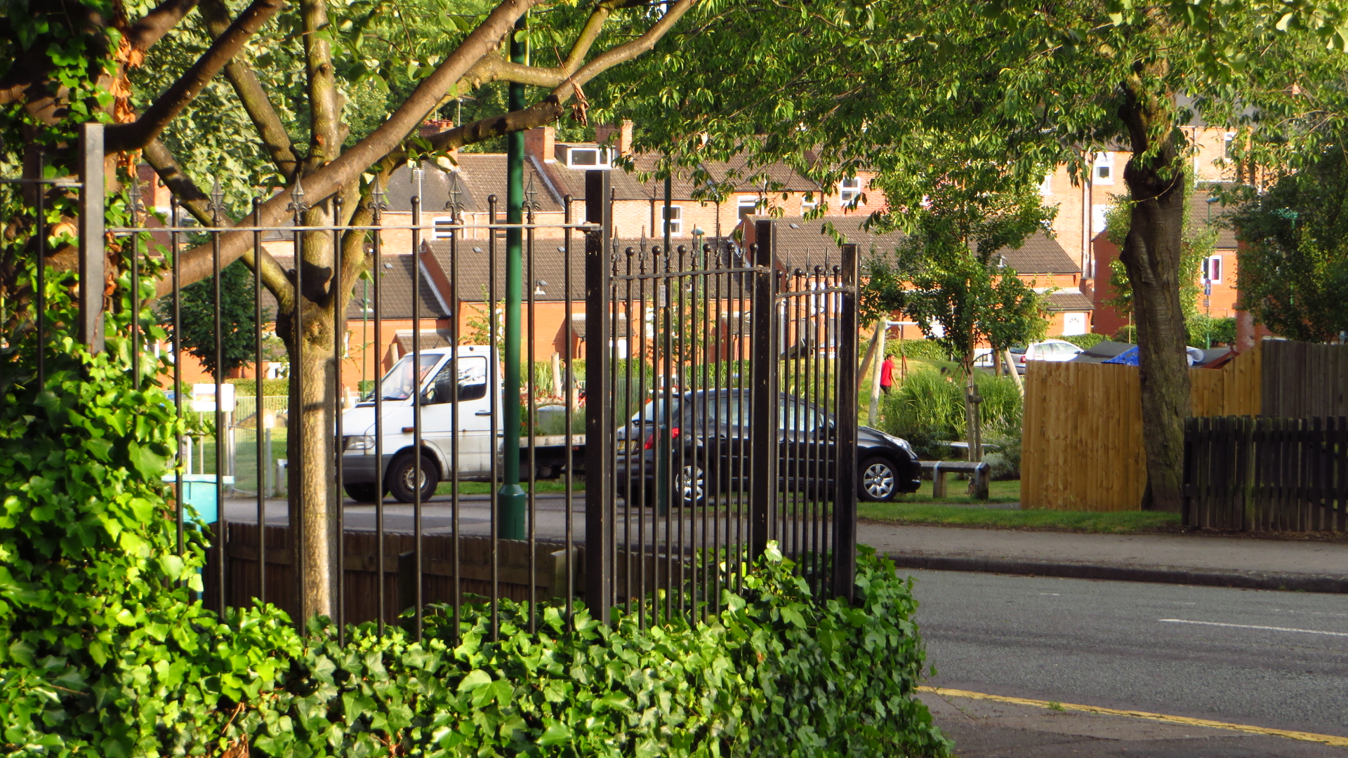 cars parked in a lot through a gate