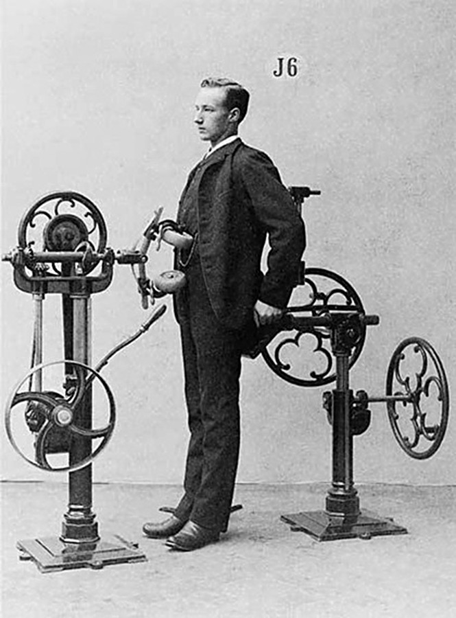 a man holding a dog standing next to a machine