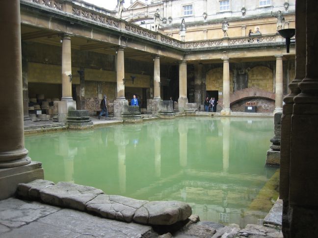 a small swimming pool in a courtyard next to some very large buildings