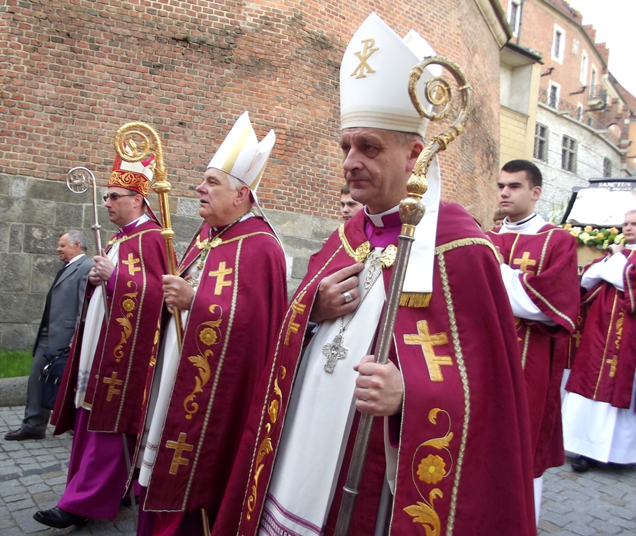the priests are standing on the street dressed in red robes