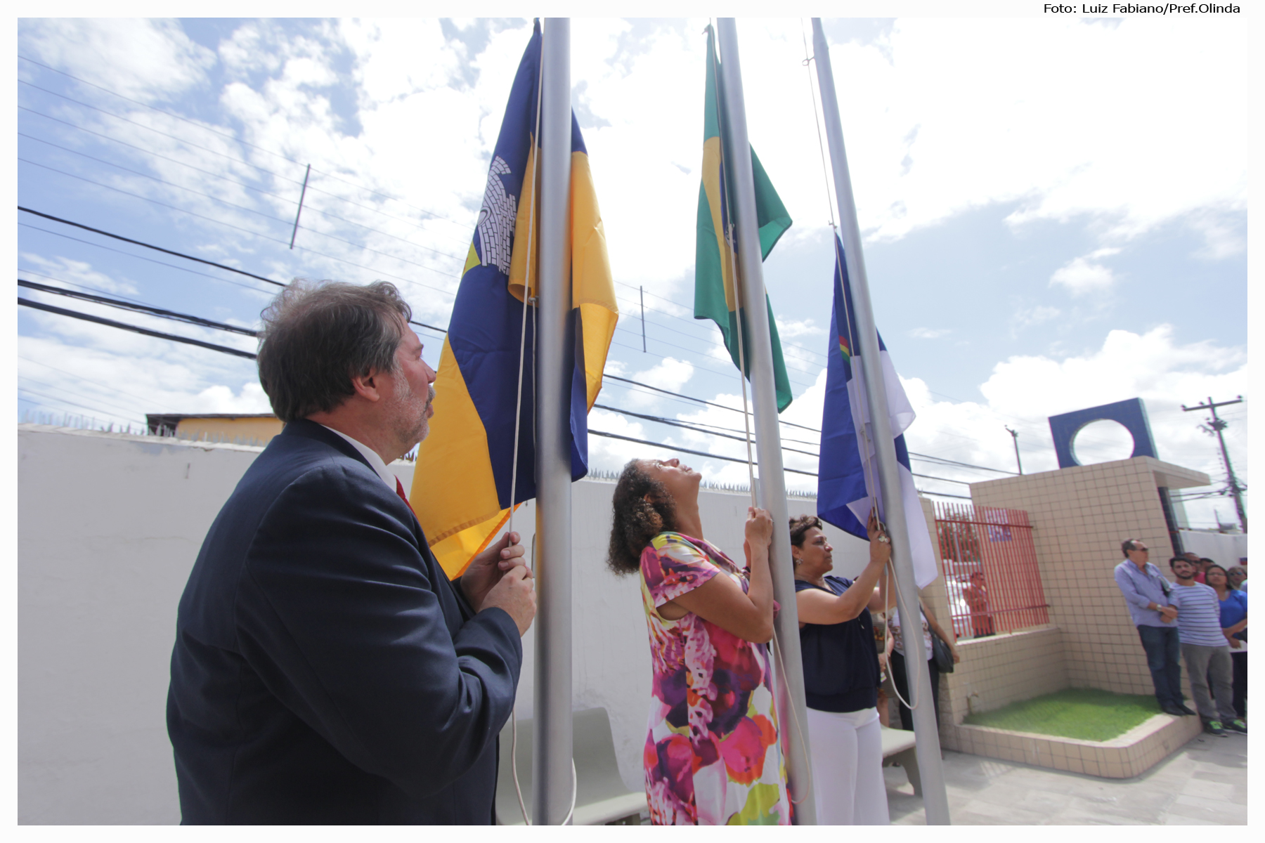 several people in a crowd stand near flags