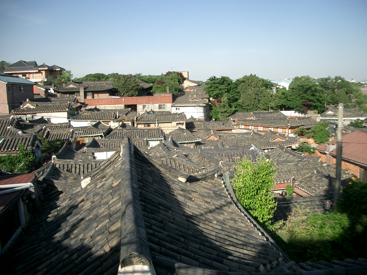 a building with roof tops and green trees