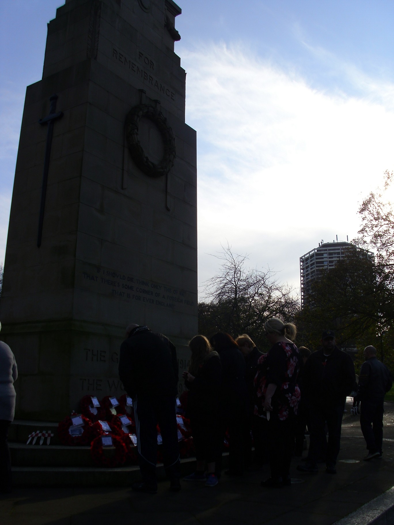 a group of people standing near a clock tower in a city