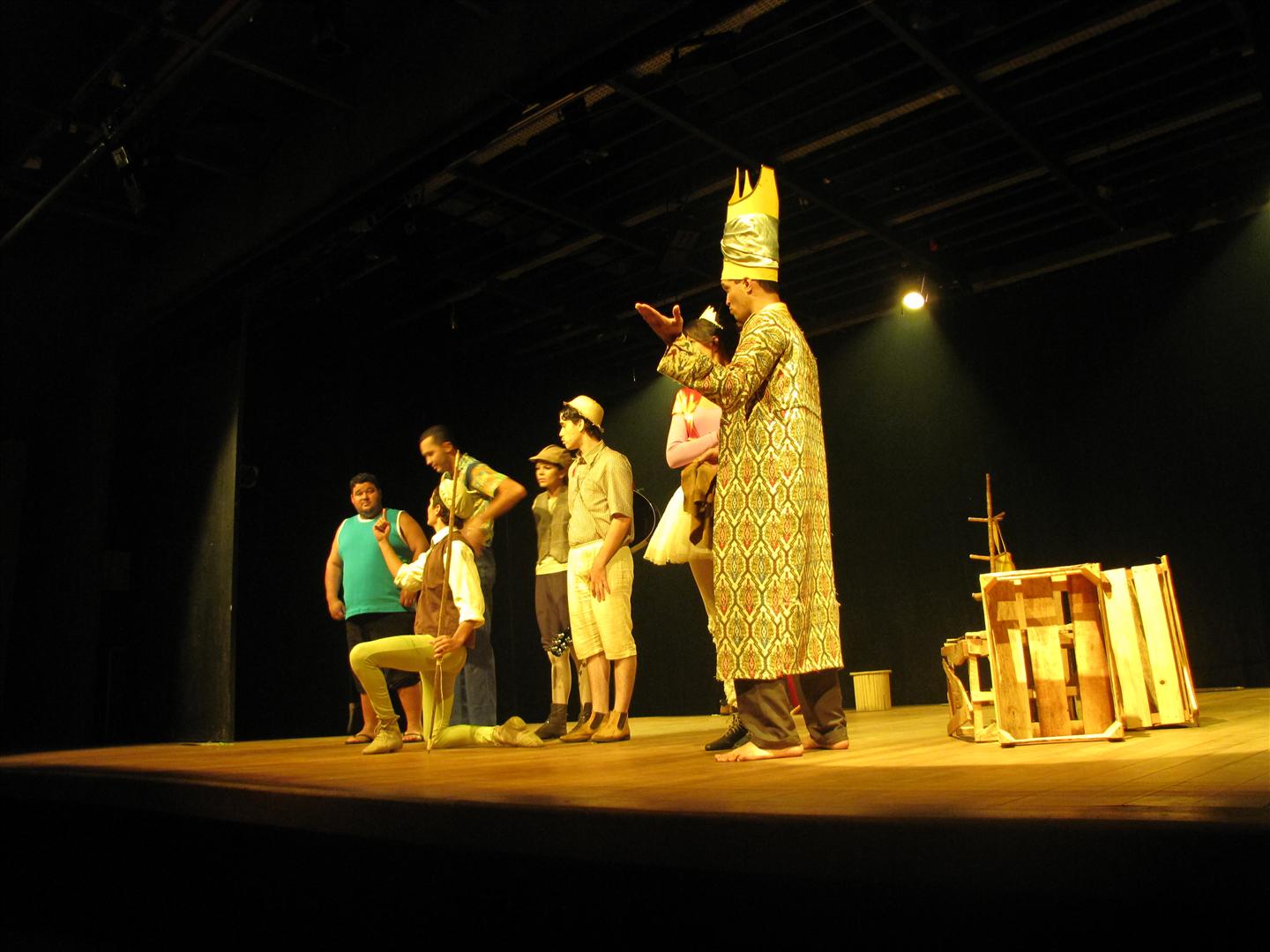 a group of people in costumes stand on stage
