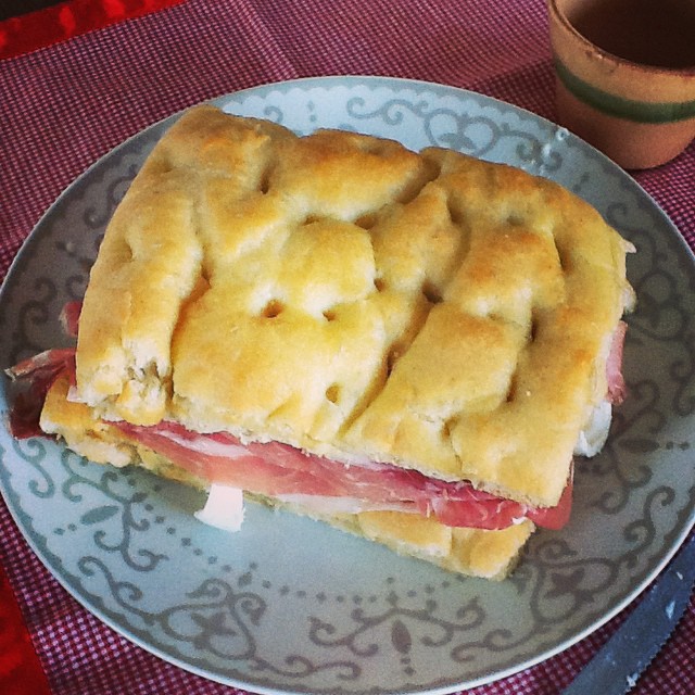 a ham and cheese biscuit sandwich sits on a plate