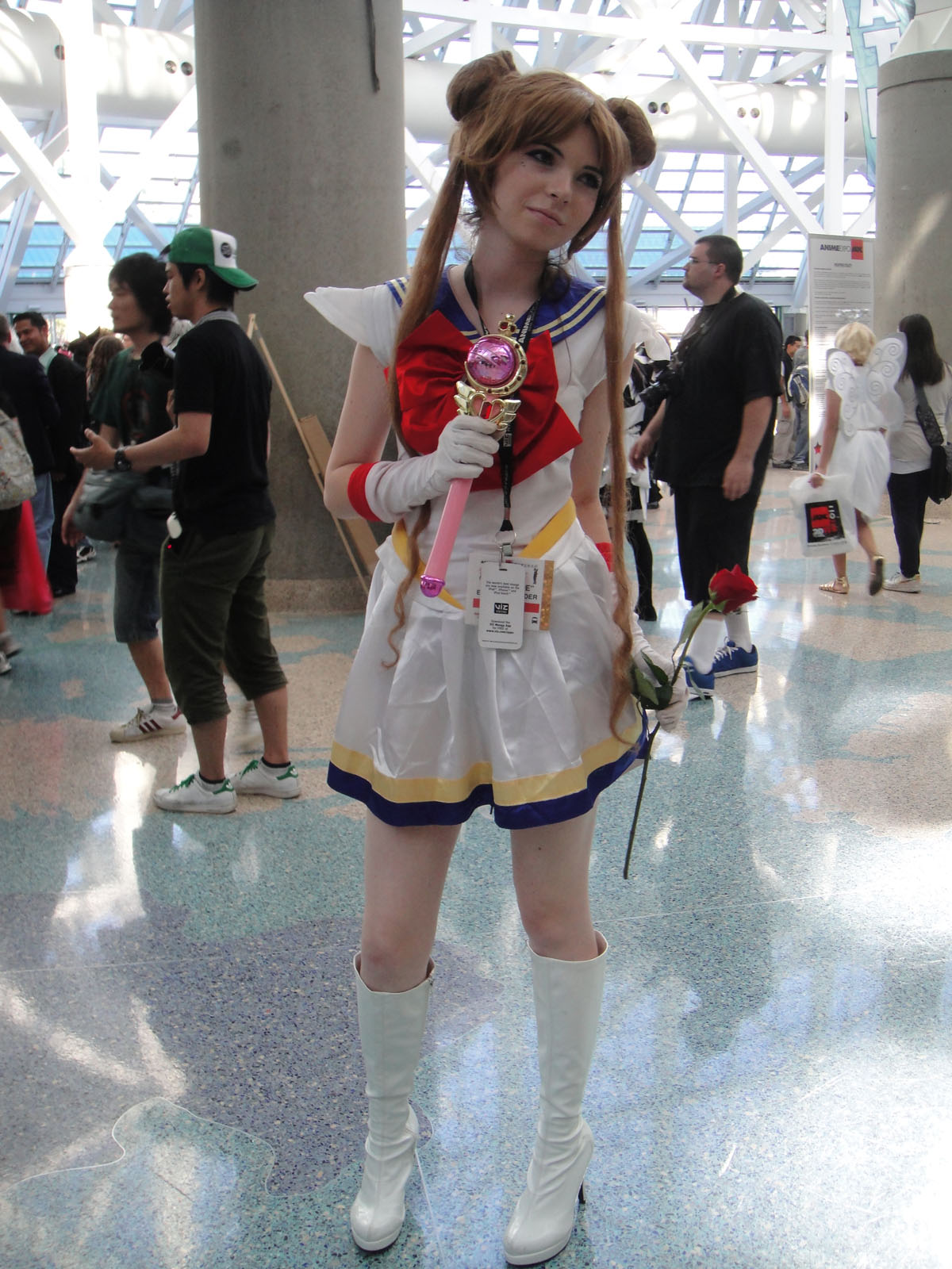 a girl in a costume holds up a plastic lollipop at a convention