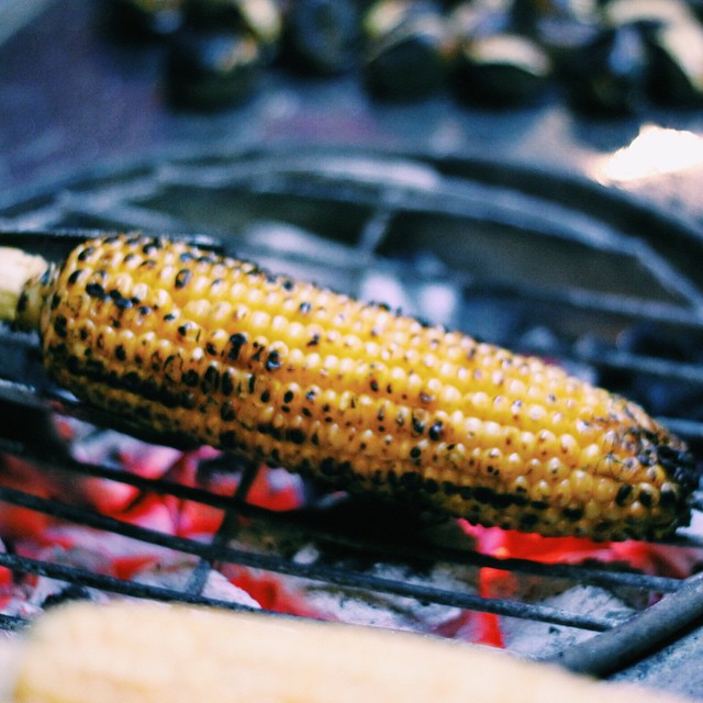 corn on the cob is being cooked over an open bbq