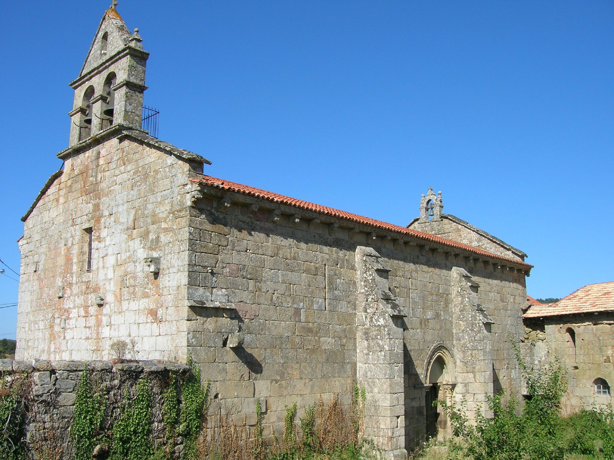 an old church with a stone wall and clock tower