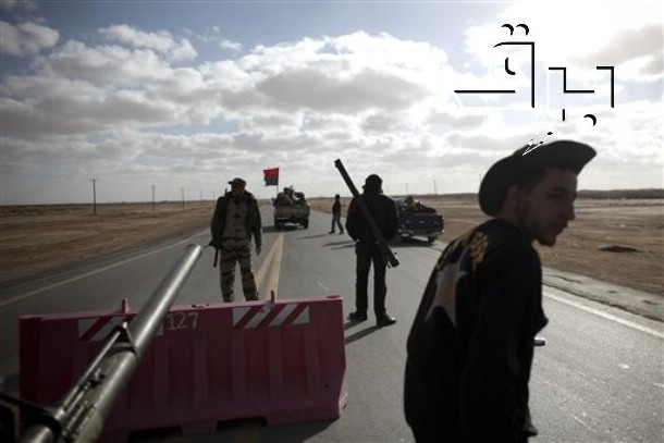 several soldiers walk on the road towards the checkpoint