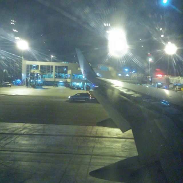 an airport with lights and a plane at night