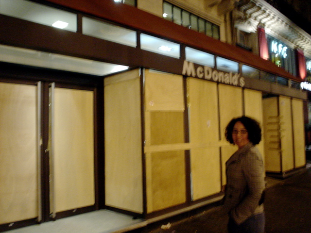 a woman standing in front of a building with doors open