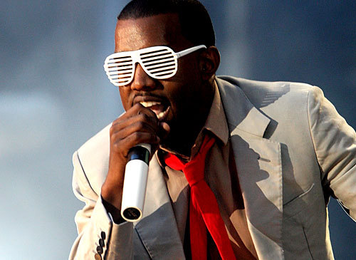 a man in sunglasses and an orange tie holding a microphone