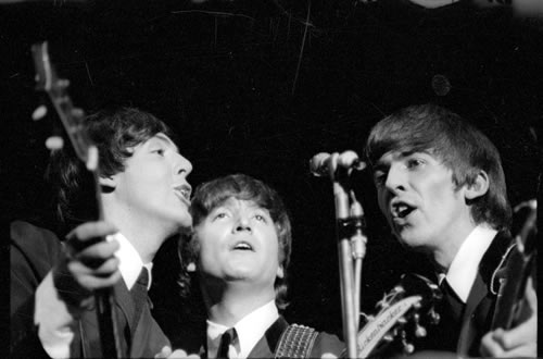beatles on stage at an event, in a black and white pograph