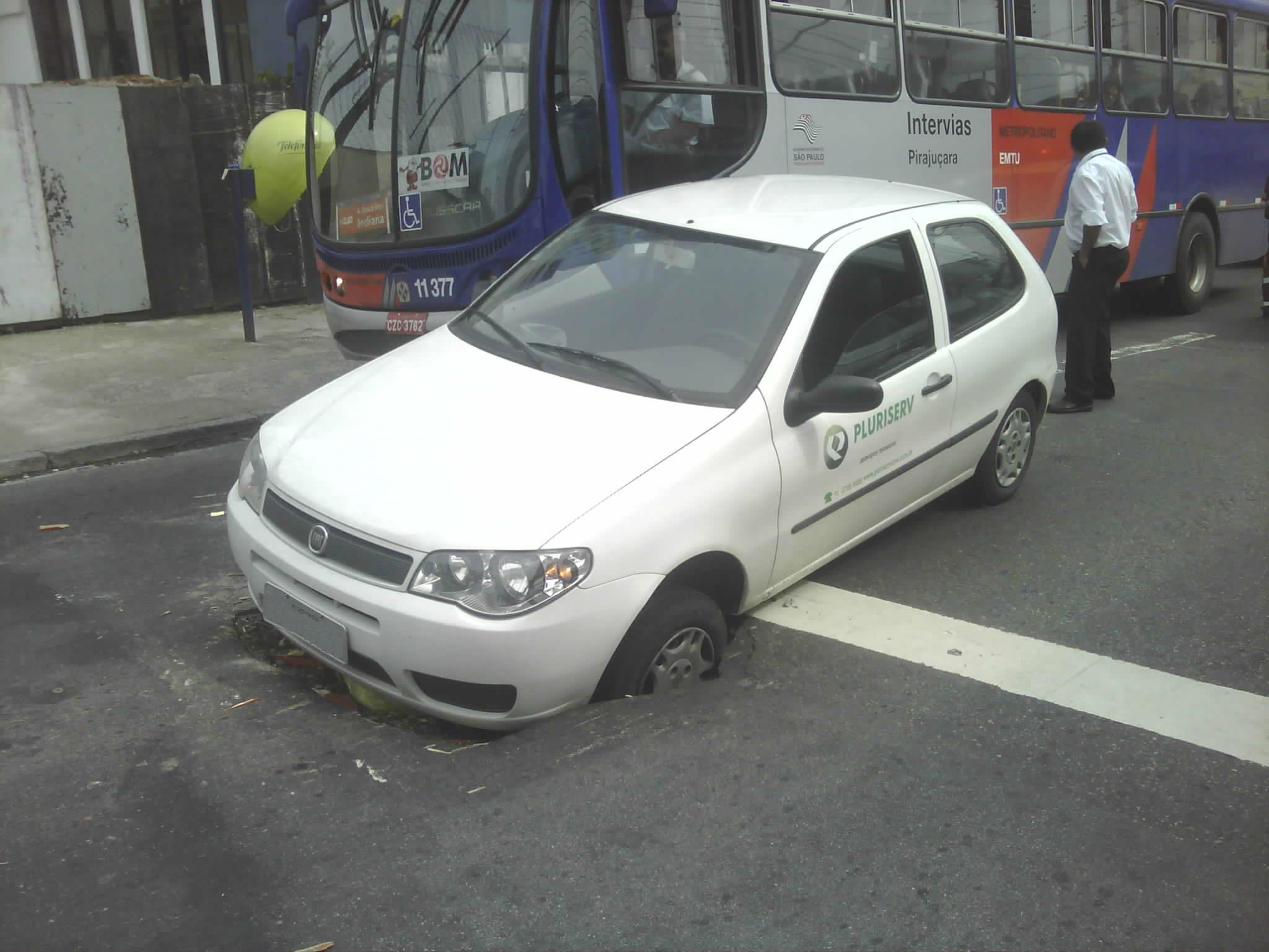 two white cars parked on the side of the road