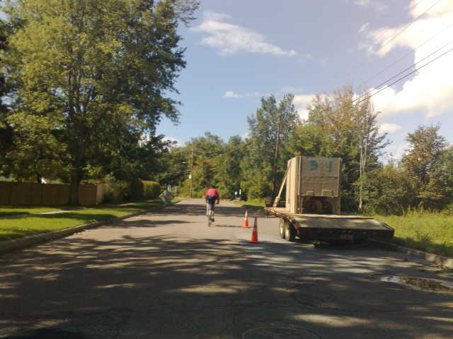 people ride down a paved road between two lanes