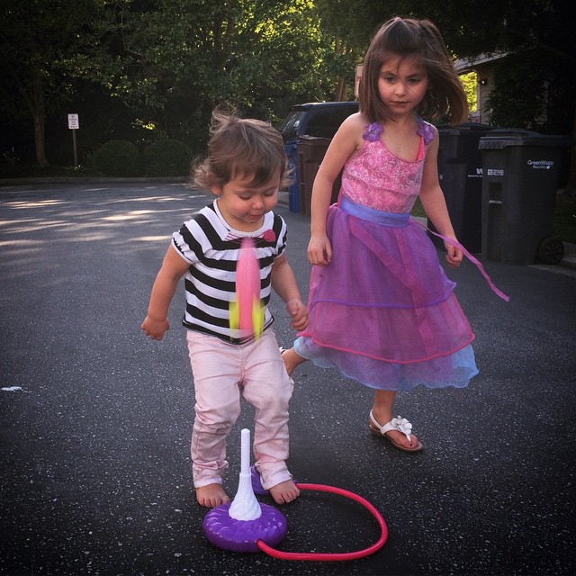 two s playing with toys on a paved road