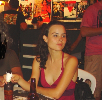 a girl is seated at a table with food and drink