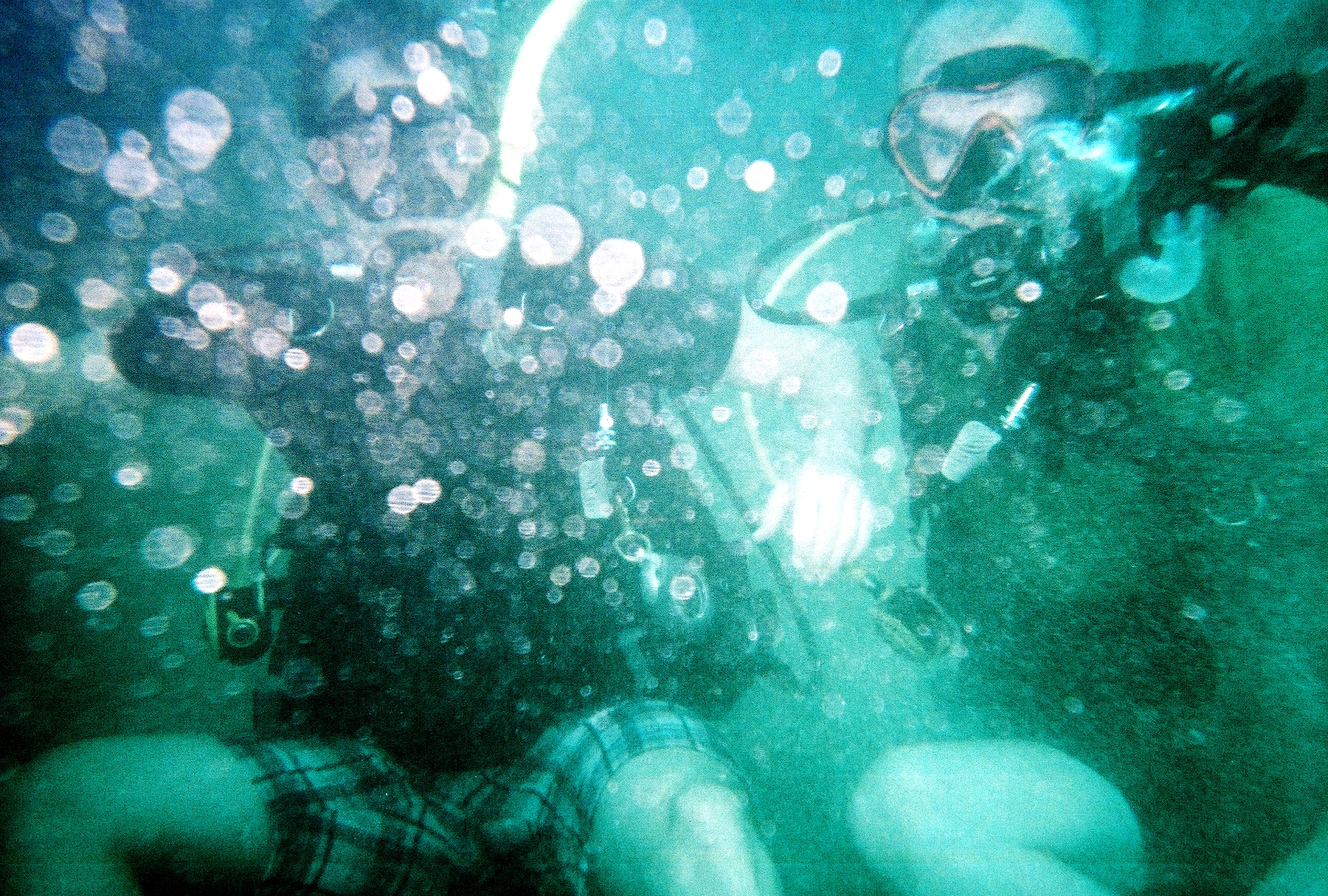 two men swimming underneath a water curtain