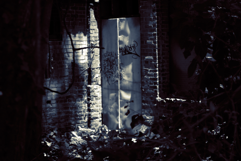 an abandoned refrigerator sits in a small brick area