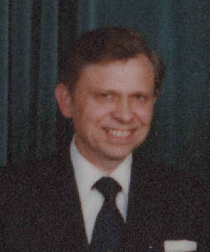 a man wearing a suit and tie smiling