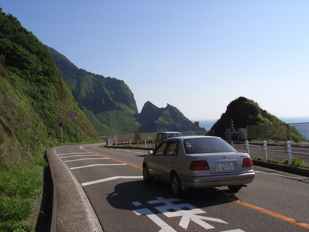 a car is shown driving on the highway through mountains