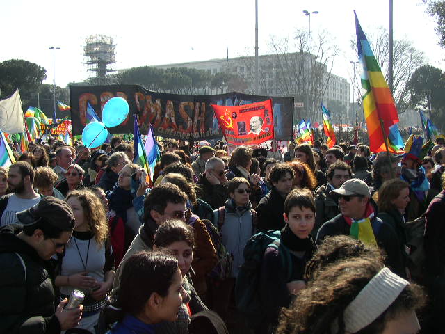 a crowd of people stand together in a crowd holding signs