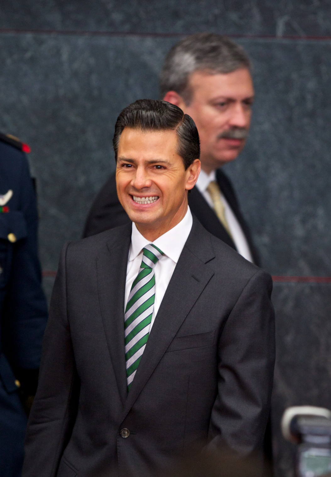 a man wearing a suit and a green and white striped tie