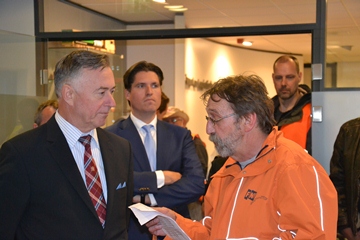 two men in orange and red jackets are speaking