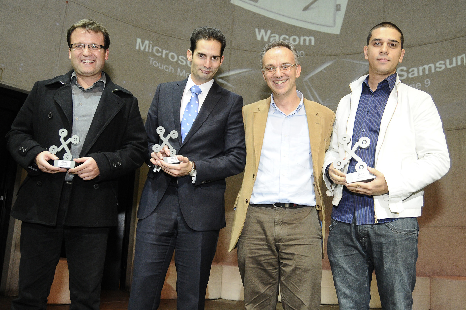 five men holding small awards next to each other