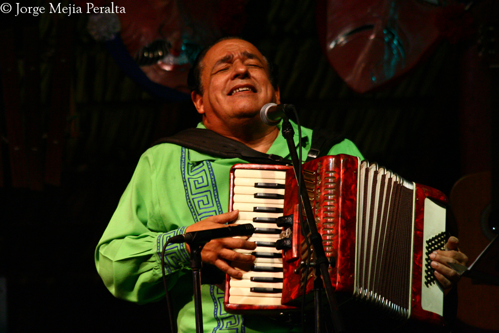man singing and playing an accordion in front of his