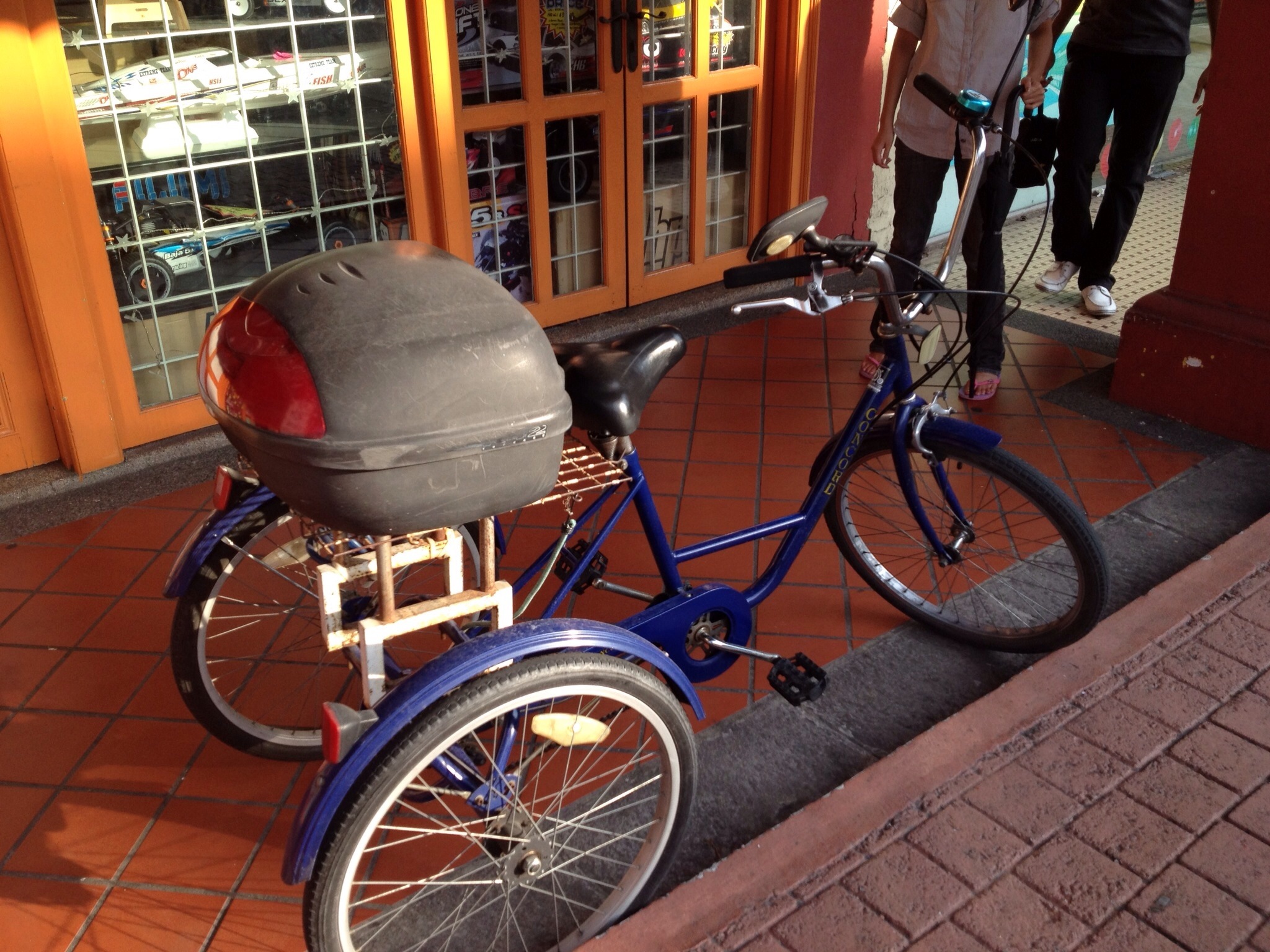 an old style tricycle with side basket sitting parked next to a building