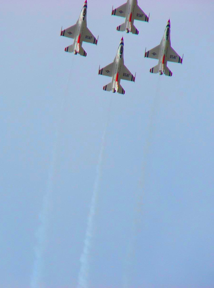 four jet airplanes fly in a blue sky