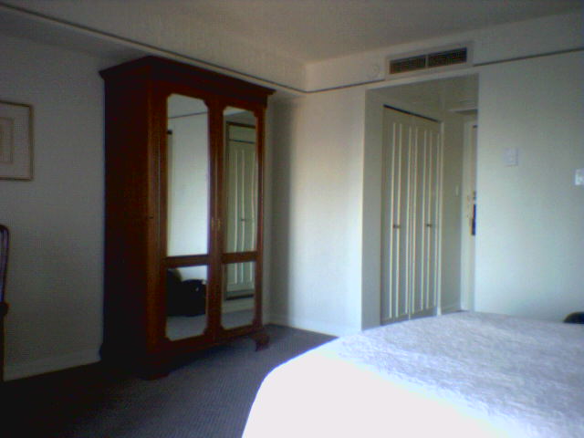 a bedroom with a bed, mirror, and dresser