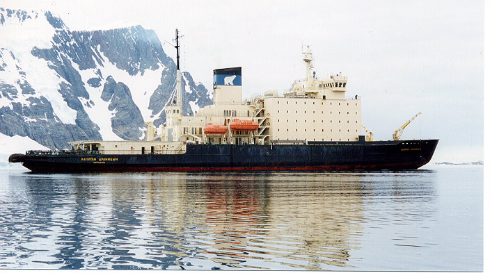 an old black and white boat floating in the water