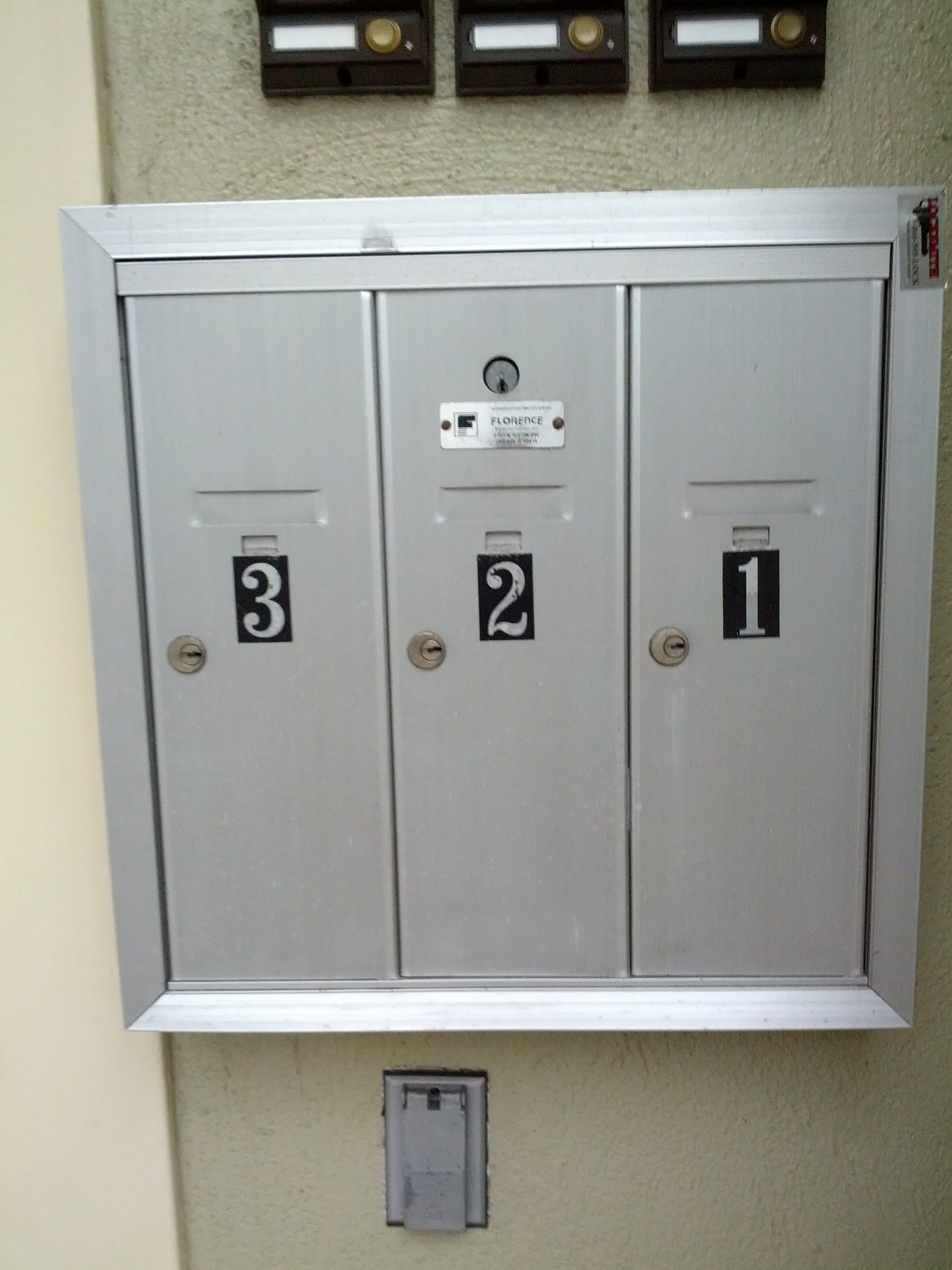 two mailboxs on a wall and the numbers is located in each panel