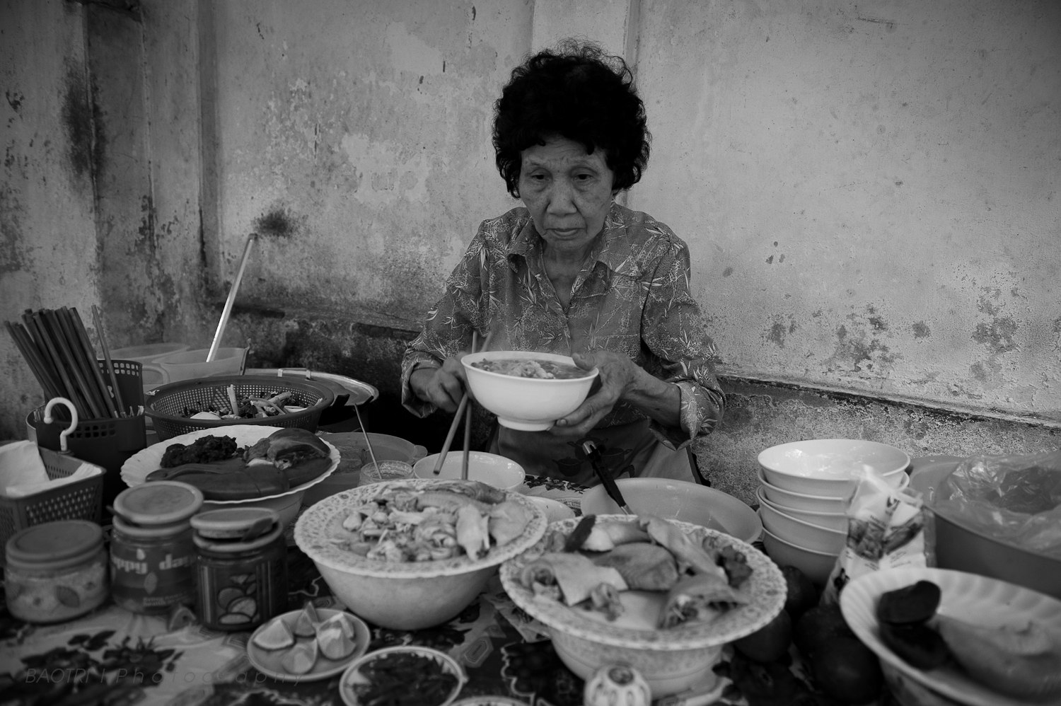 a woman sitting on a table full of dishes