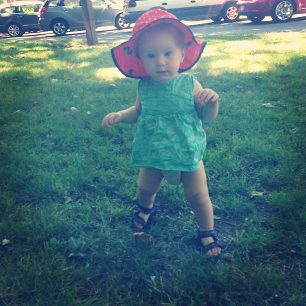 a little girl dressed up in a sun hat